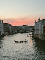 A couple enjoying a serene gondola ride through Venetian canals at dusk.