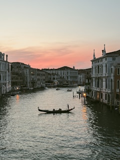 A couple enjoying a serene gondola ride through Venetian canals at dusk.