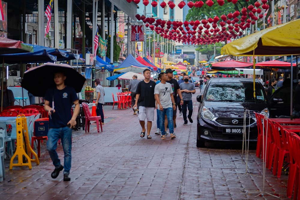 a group of people walking down a street holding umbrellas