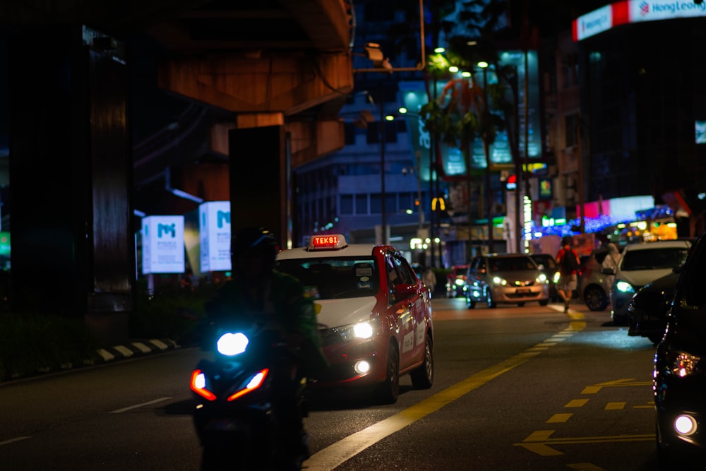 a busy city street at night with cars and motorcycles