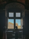 a couple of people standing in front of a window