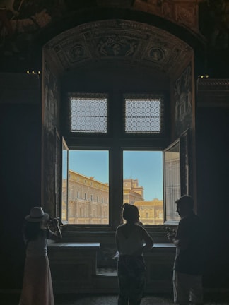 a couple of people standing in front of a window