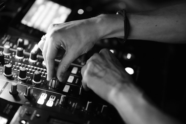 Close-up of DJ equipment with hands skillfully mixing tracks in a studio.