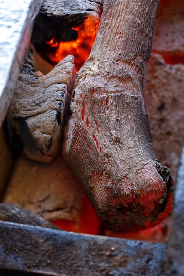 Close-up of smoked wood chips glowing softly in a traditional smoker.