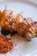 Close-up of a vibrant seasoning blend sprinkled over grilled chicken on a rustic wooden table.