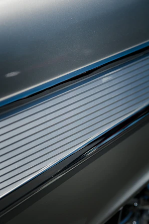 Detail of textured steel alloy sheets reflecting light in a modern facility