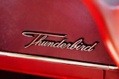 A close-up shot of the Tharbook logo in premium red and gold colors on a bright background.