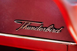 A close-up shot of the Tharbook logo in premium red and gold colors on a bright background.
