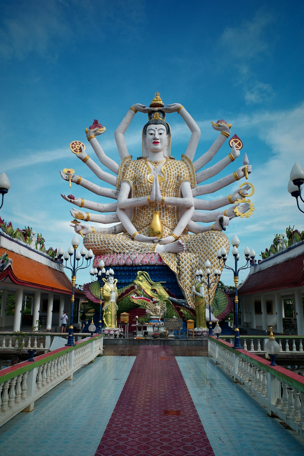 a large statue of a person sitting in the middle of a walkway