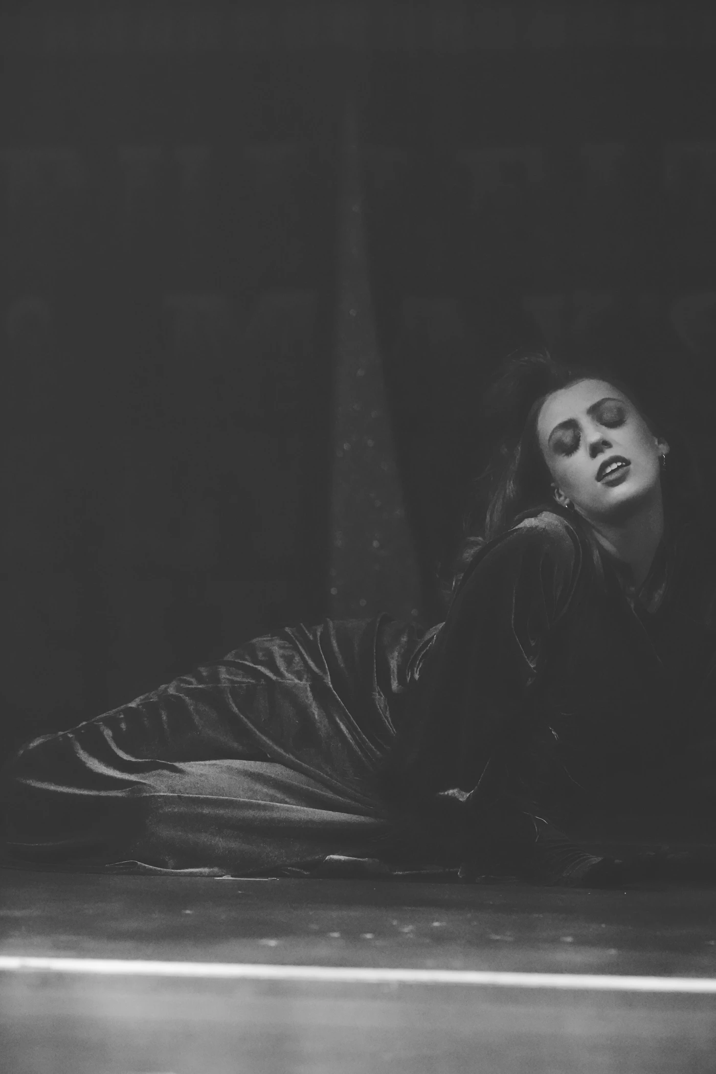 Burlesque performer lounging on stage — black and white