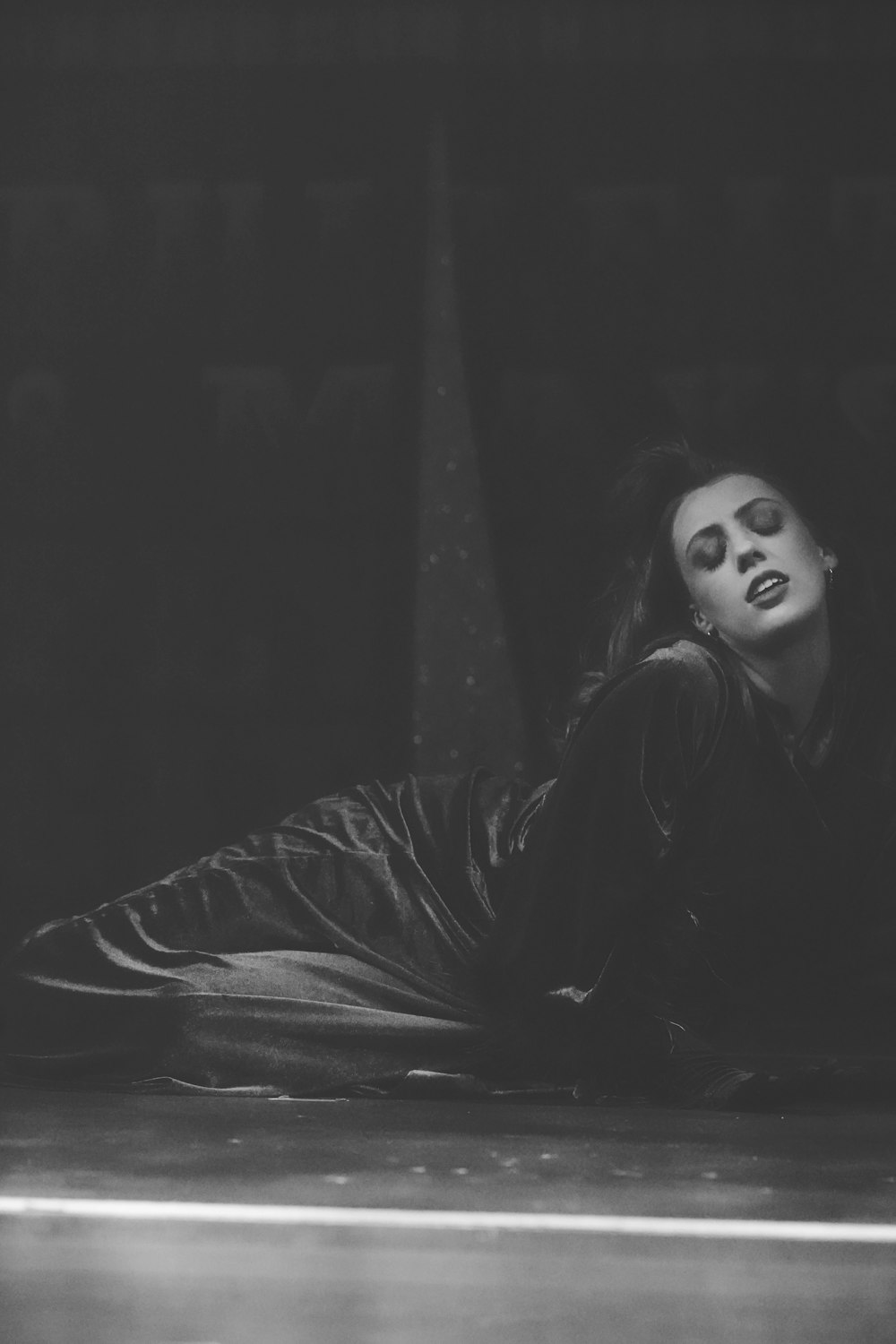 a black and white photo of a woman laying on the ground