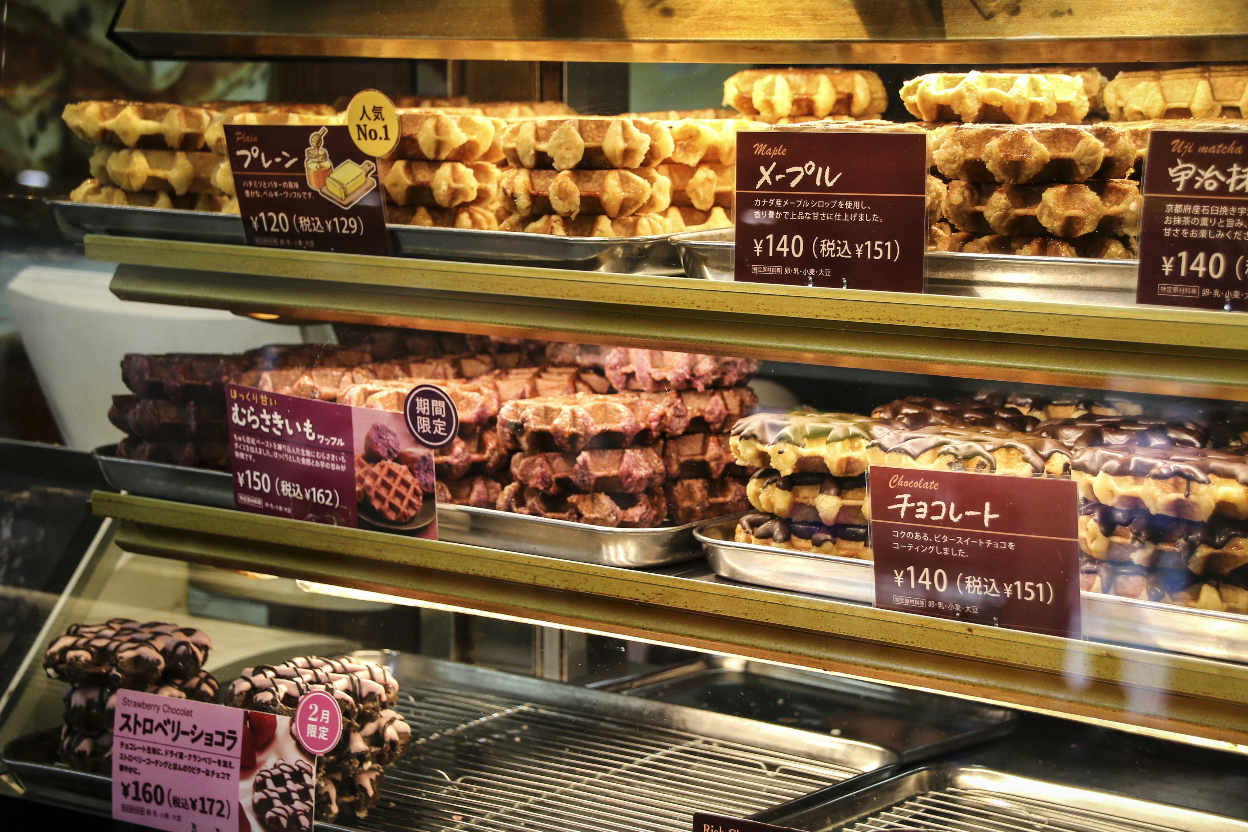 a display case filled with lots of different kinds of donuts, Waffle