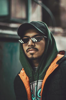 Urban model wearing a layered hoodie and tee combo in cool gray and neon lime green on a gritty city backdrop.