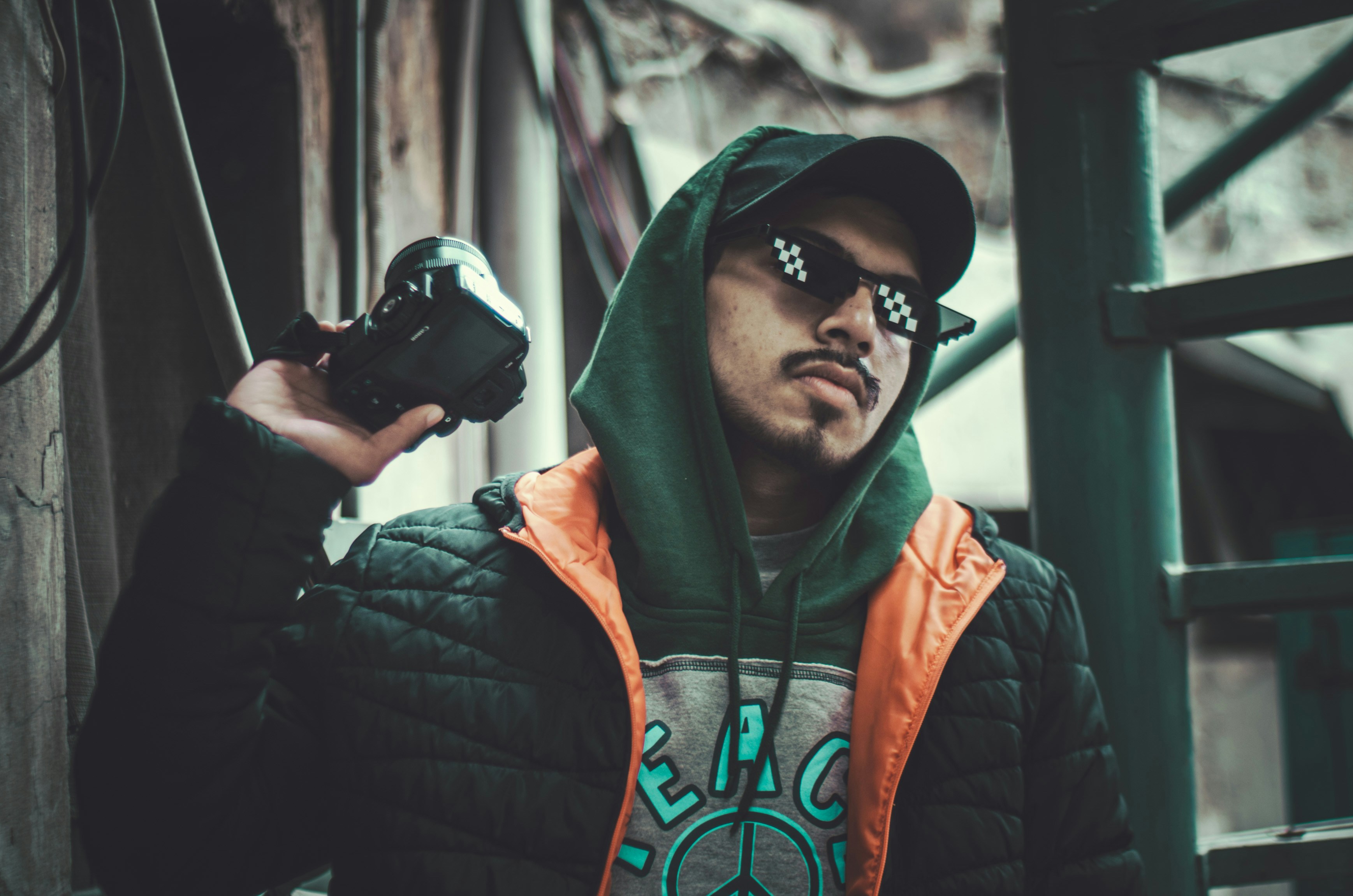 a man in a hoodie holding a camera