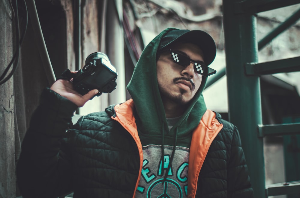 a man in a hoodie holding a camera