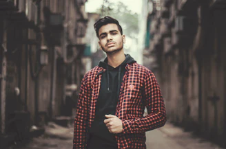 A stylish man wearing a comfortable hoodie and jeans, standing confidently in an urban setting.