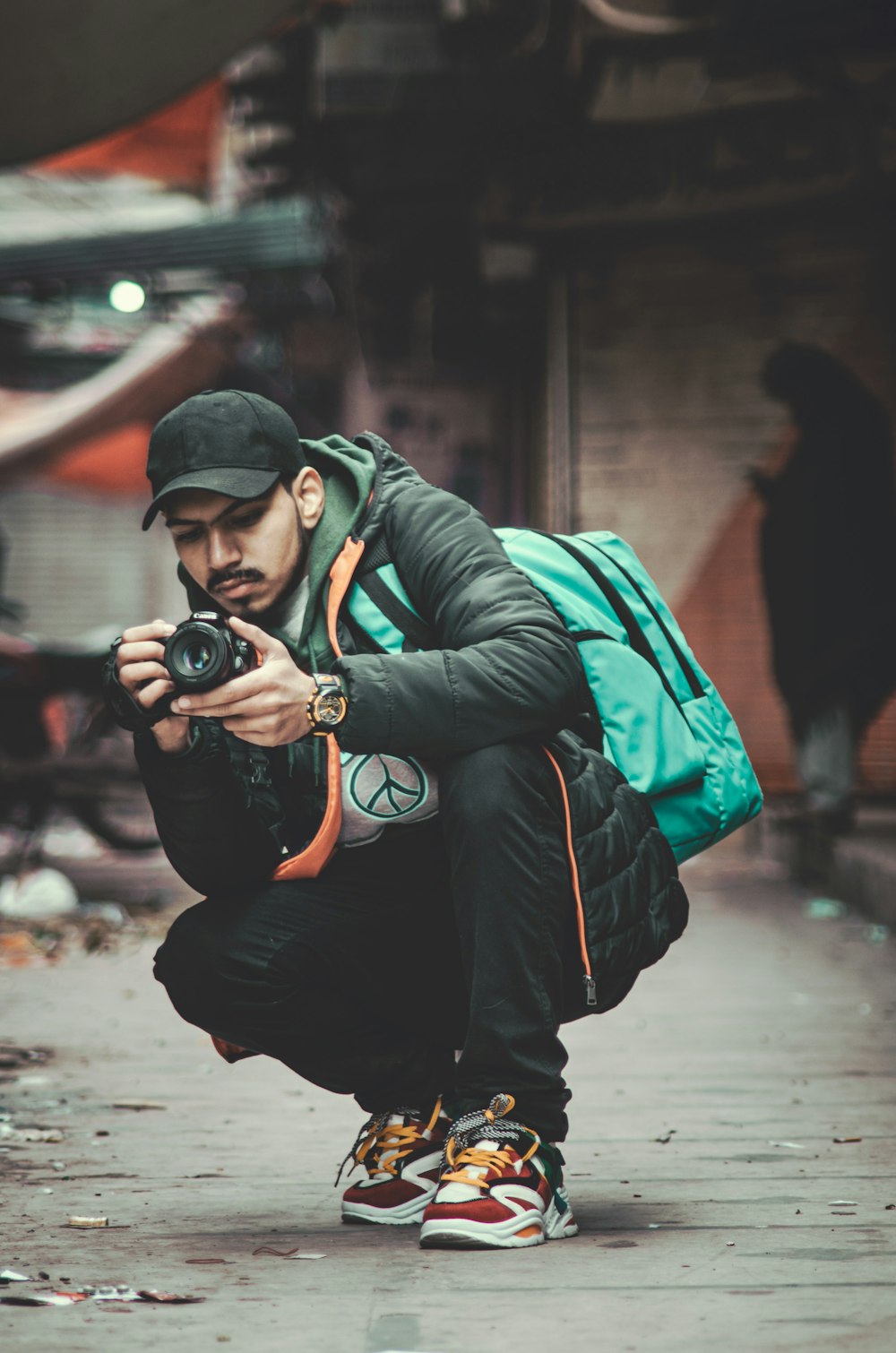 a man kneeling down with a camera in his hand