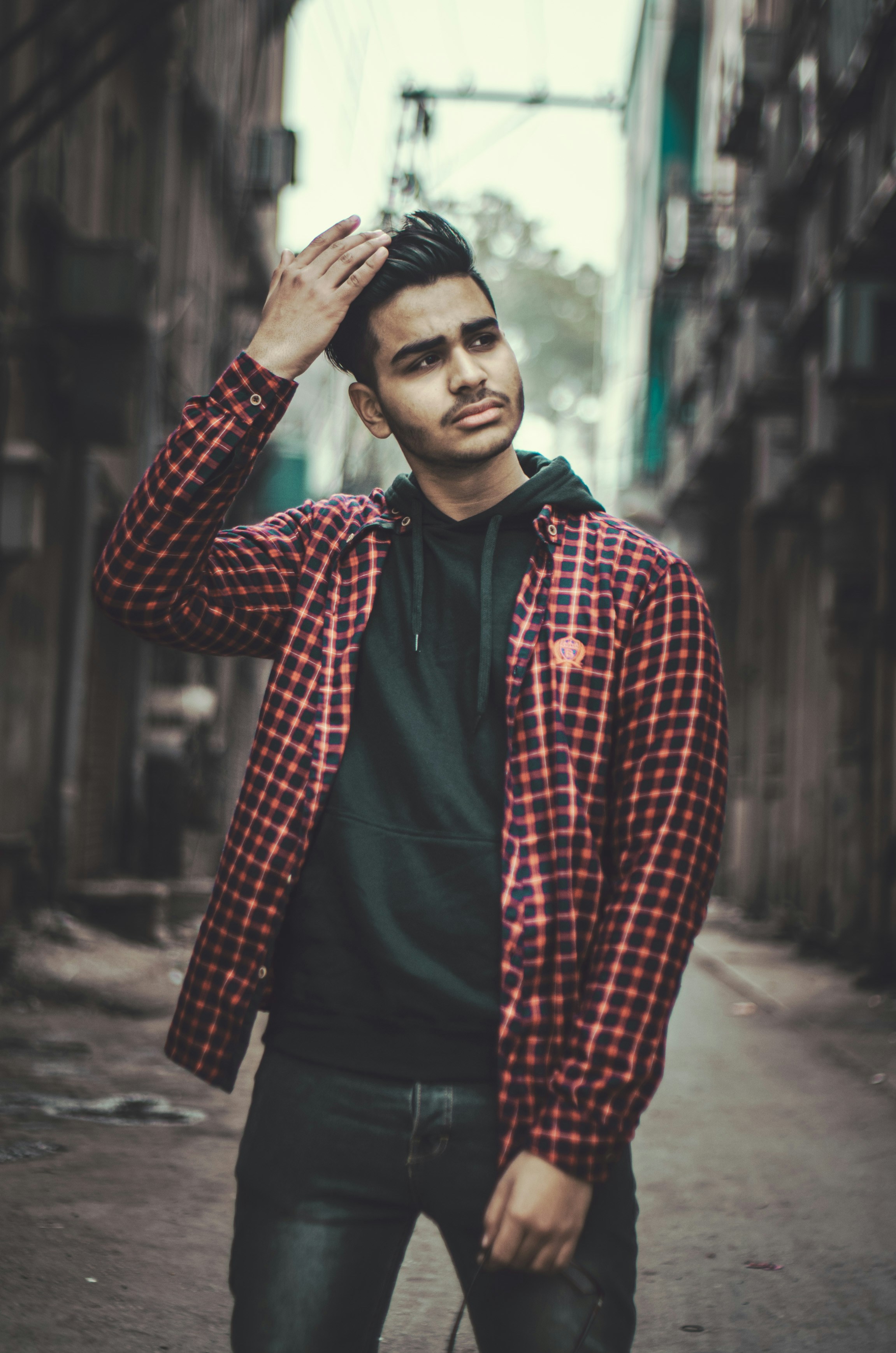 Un hombre con una chaqueta a cuadros roja y negra parado en una calle foto  – Imagen de Retrato gratuita en Unsplash, image size:3000x4529