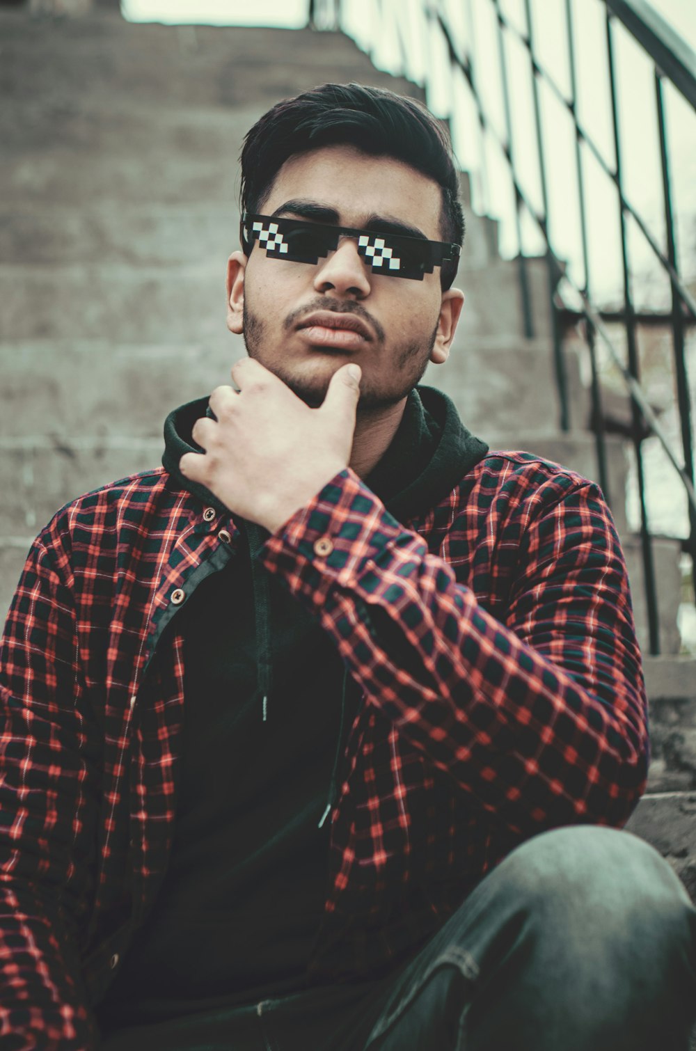 a man wearing sunglasses sitting on the steps