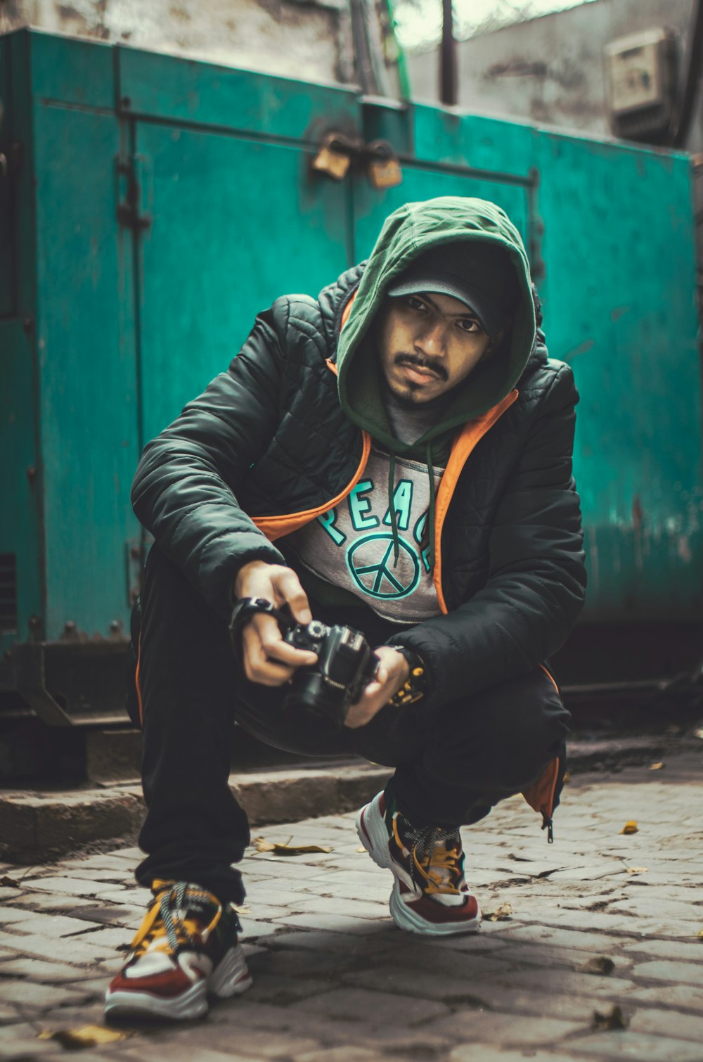 a man kneeling down with a camera in his hand