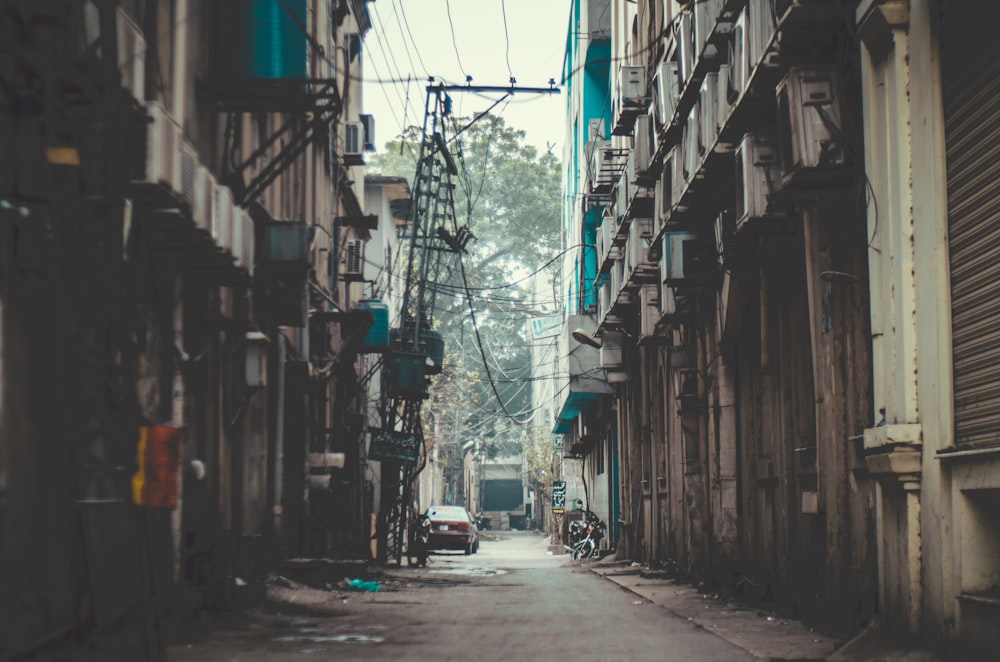 an alley way with a car parked on the side of it