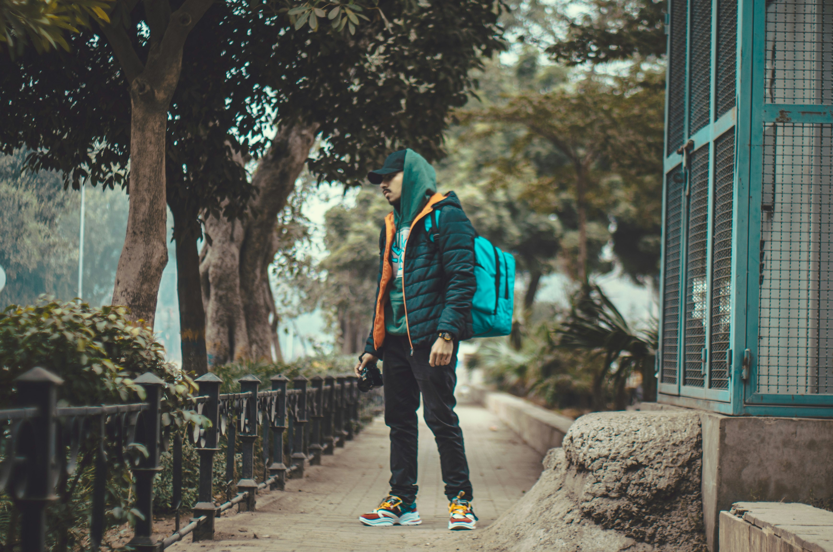 a man with a backpack standing on a sidewalk