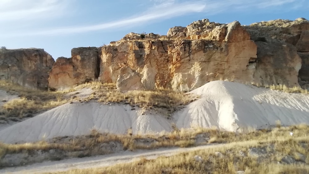 a group of large rocks sitting on top of a dry grass field