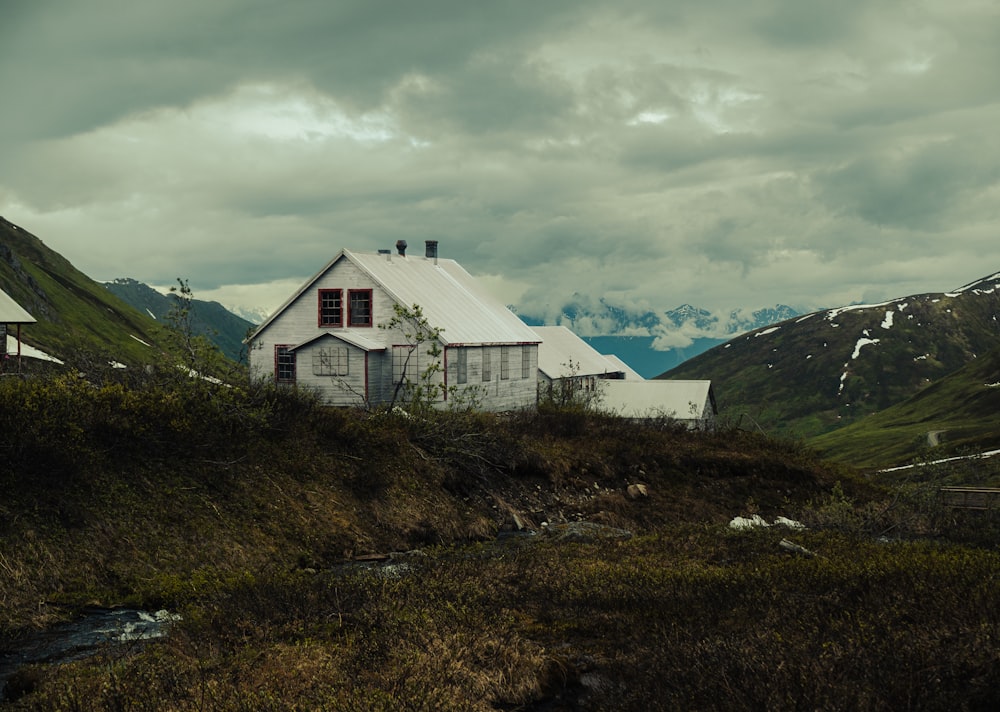 a house on a hill with mountains in the background