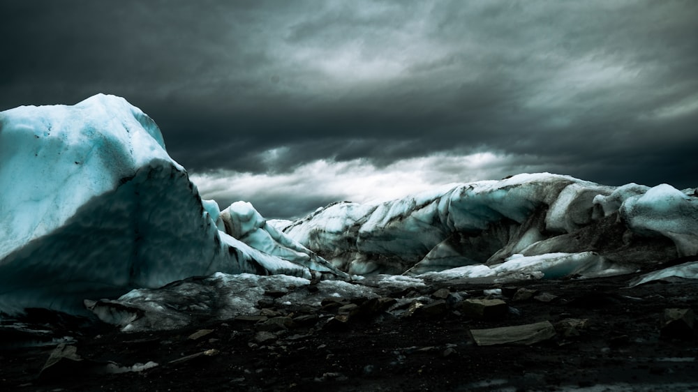 a large iceberg sitting on top of a rocky beach