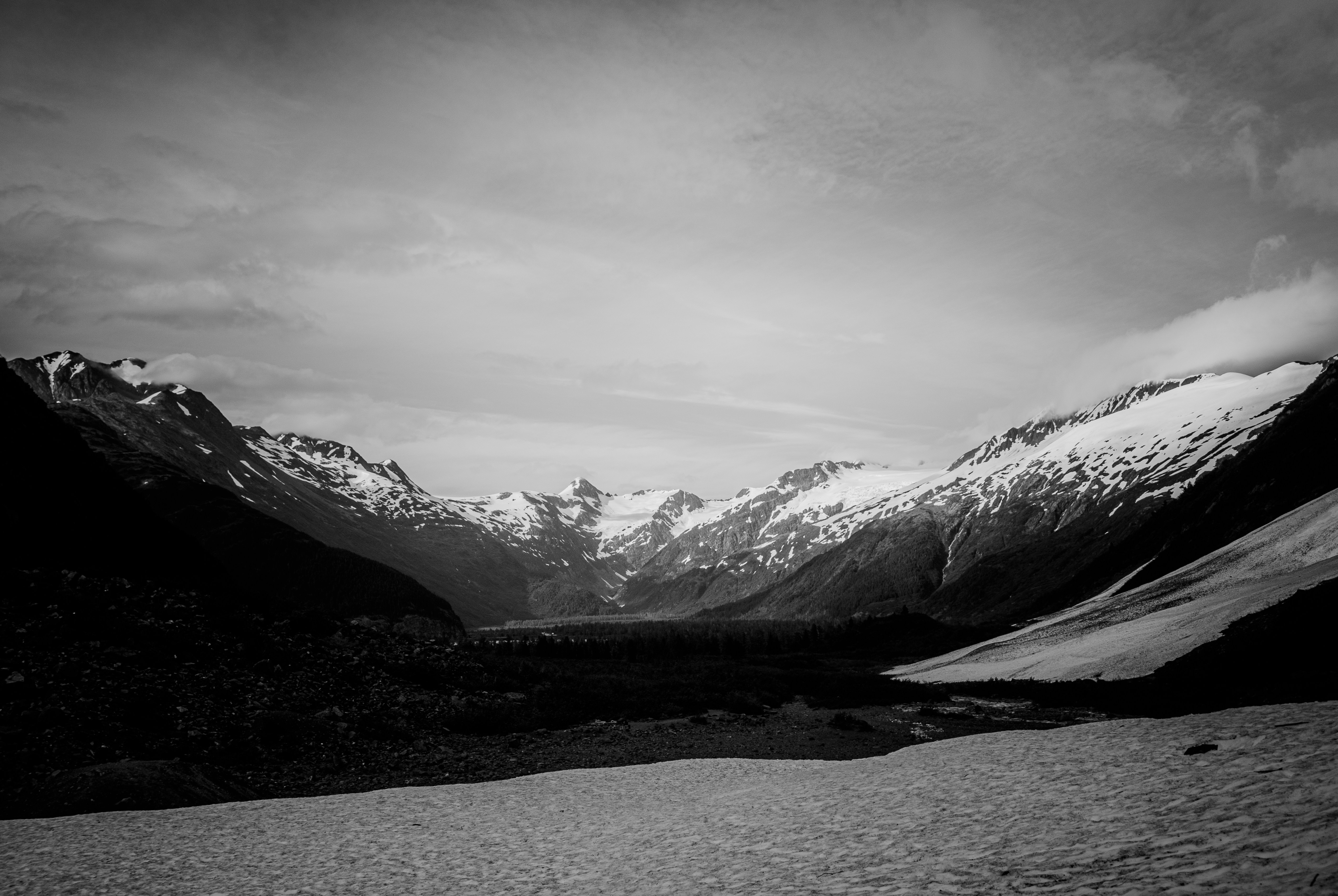a black and white photo of snow covered mountains