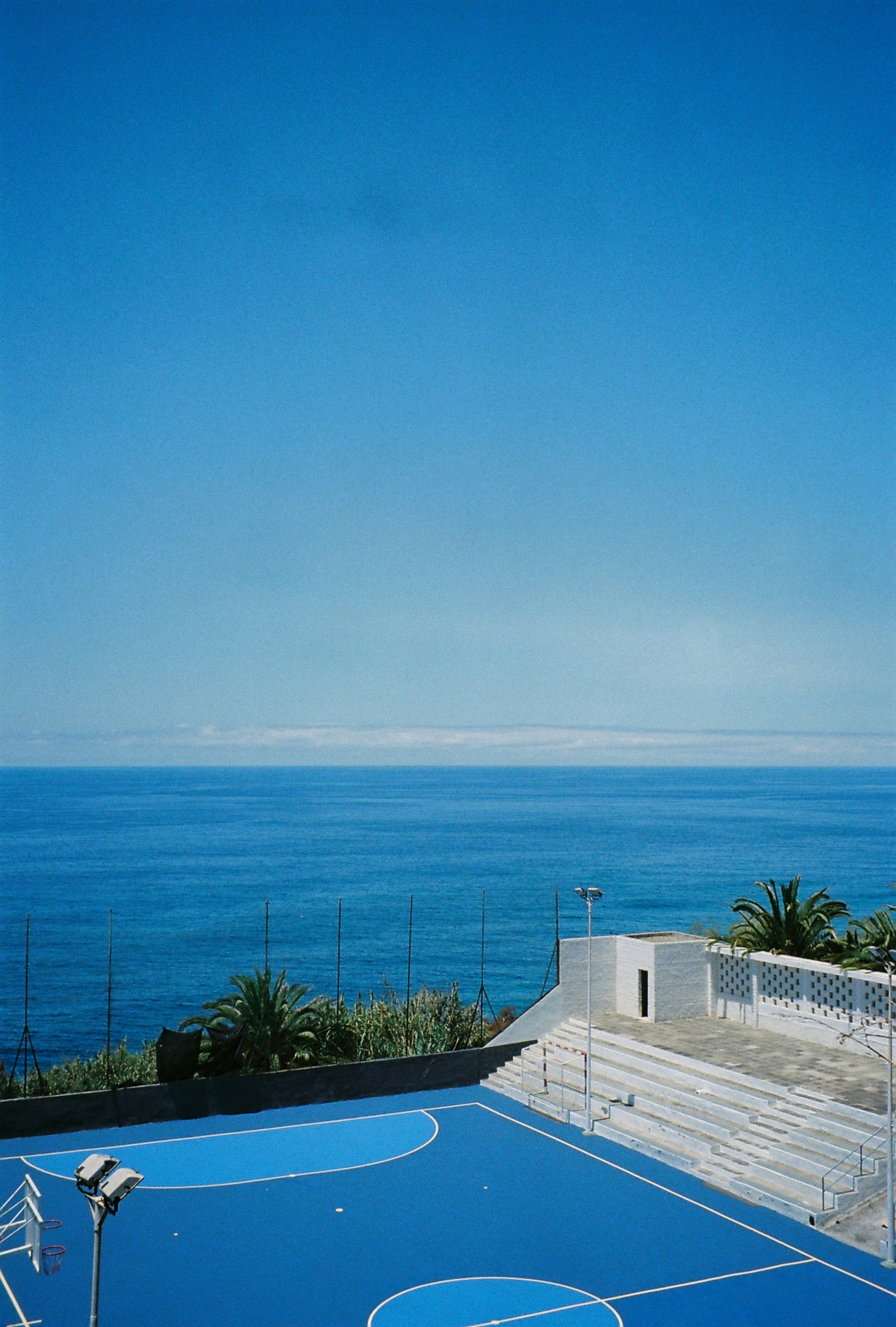 a tennis court with a view of the ocean