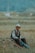 a man sitting in the middle of a field