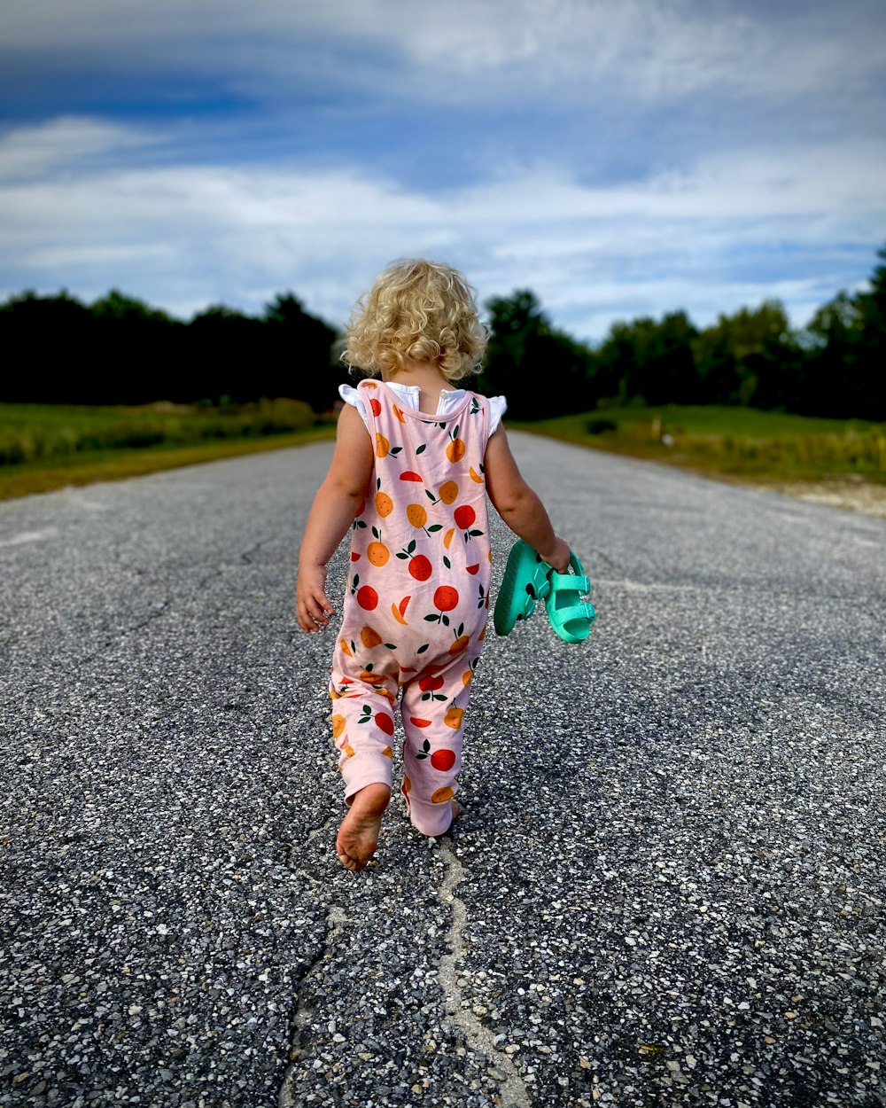 a little girl walking down the middle of a road