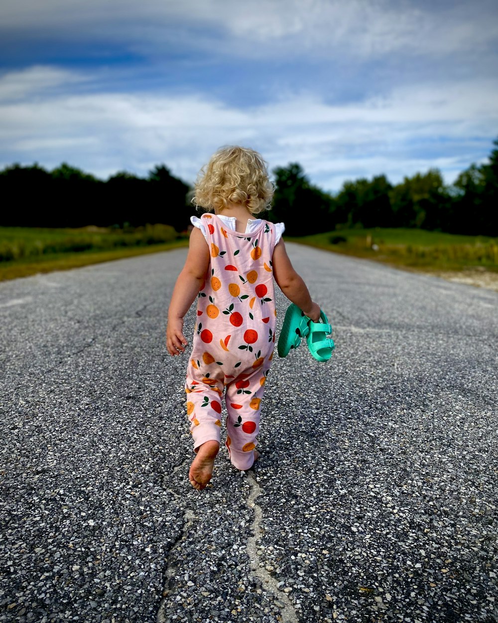 Una bambina che cammina lungo il mezzo di una strada