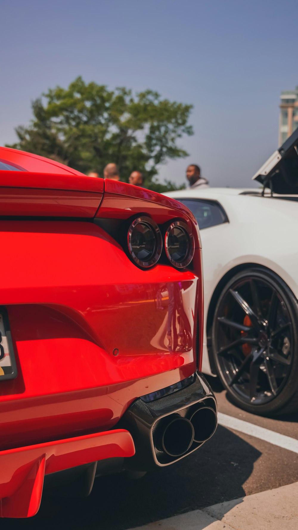 a red sports car parked next to a white sports car