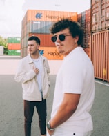 Handshake between international partners against a backdrop of shipping containers.