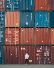 Customs officers reviewing shipping documents beside stacks of agricultural products.