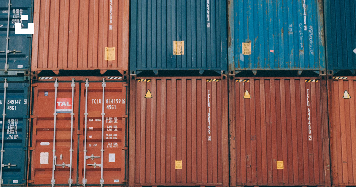 A man standing in front of a large stack of shipping containers photo ...