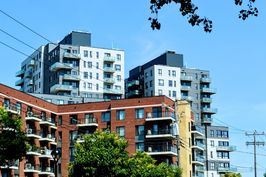 Image showing a cluster of modern, green-roofed apartment buildings surrounded by trees.