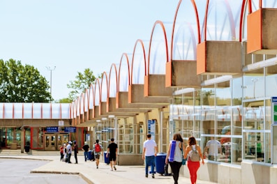 a group of people walking down a sidewalk next to a building
