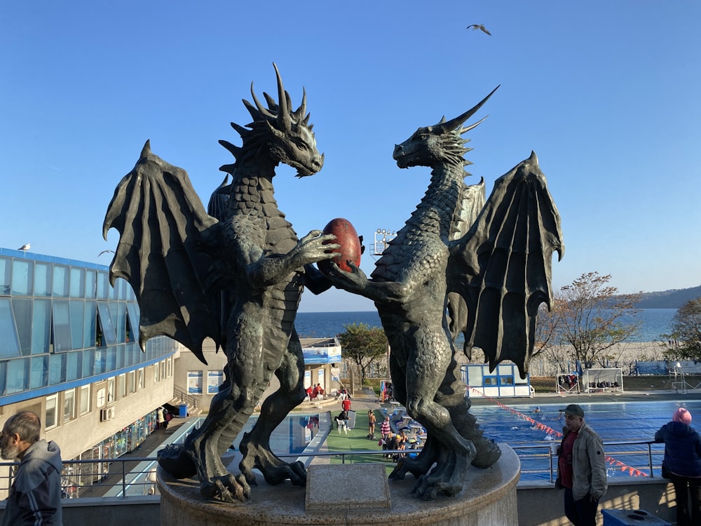 Una estatua de dos dragones peleando por una pelota de fútbol
