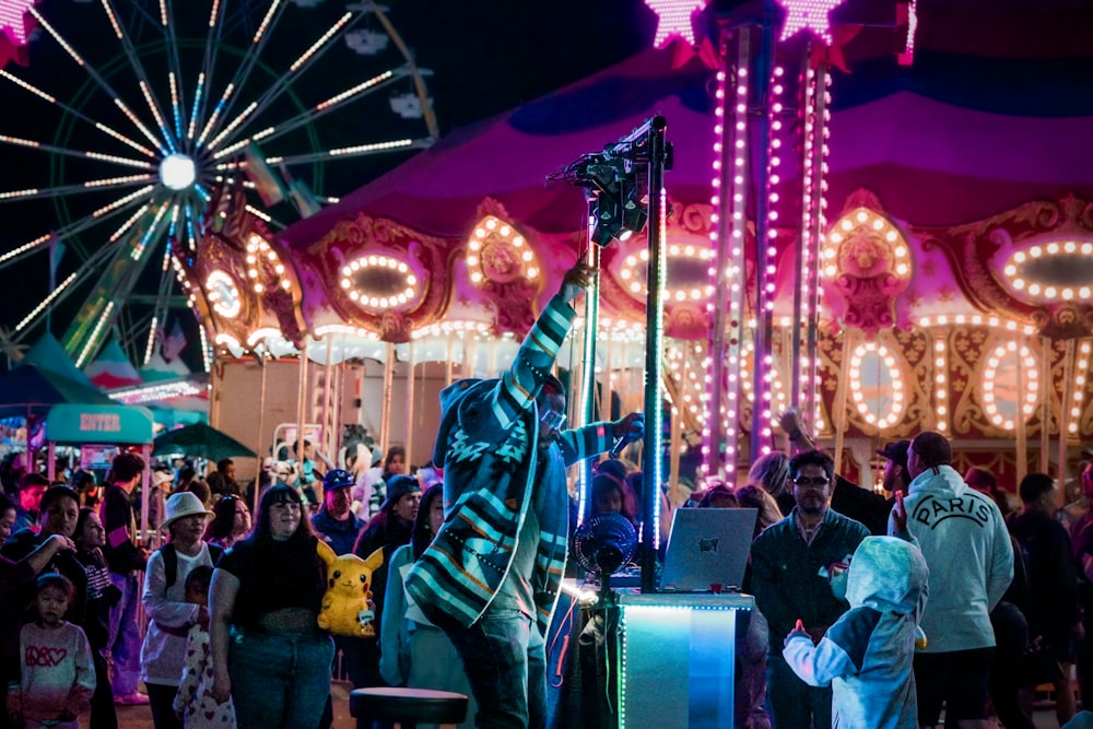 a crowd of people standing around a carnival ride