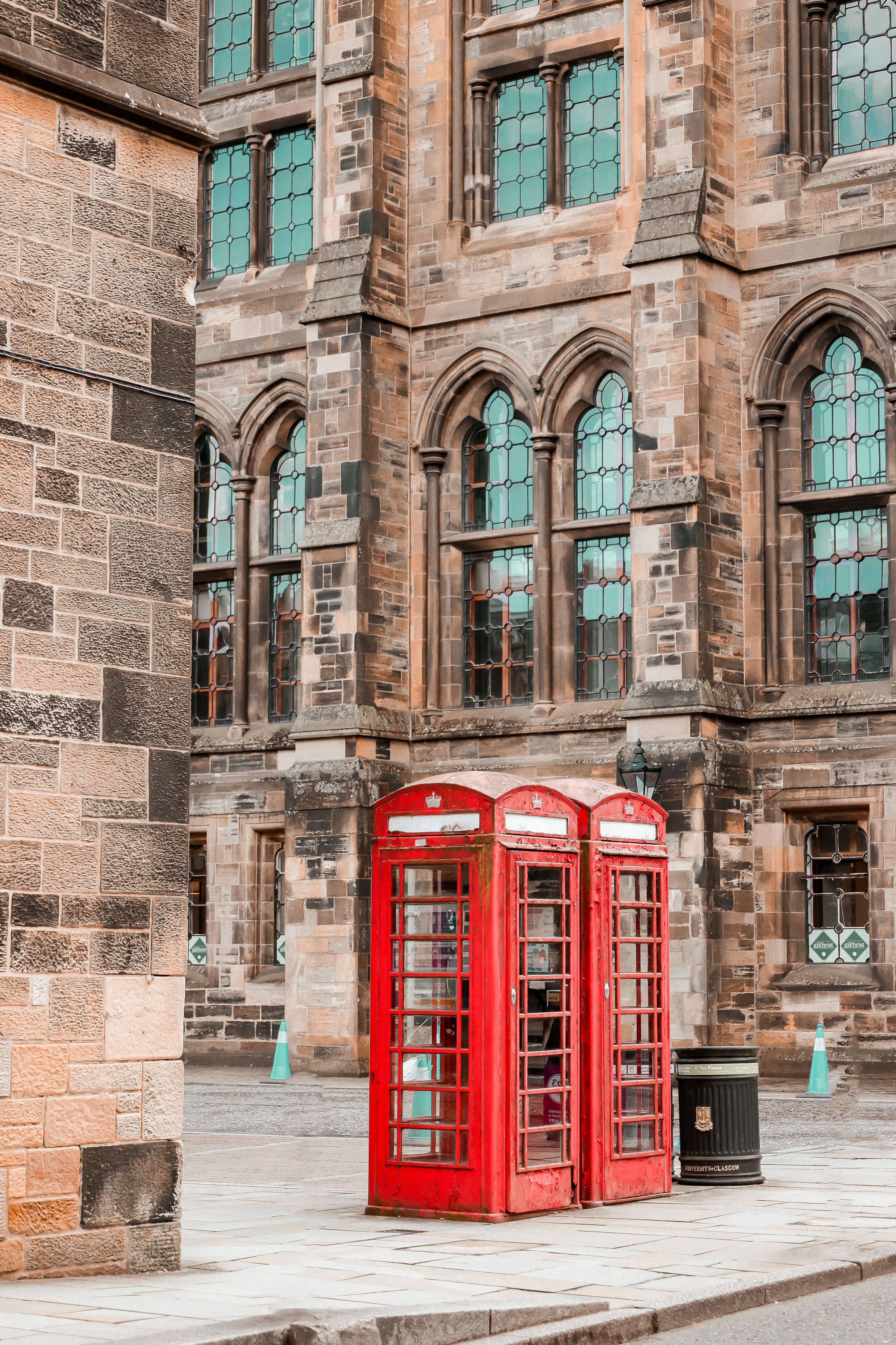 um par de cabines telefônicas vermelhas sentadas em frente a um prédio