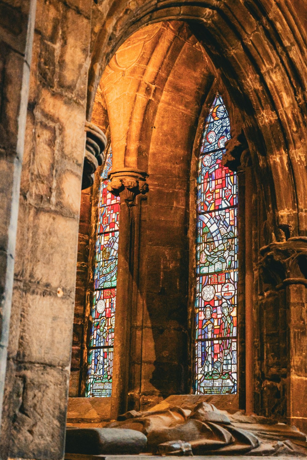 a large stone building with two stained glass windows