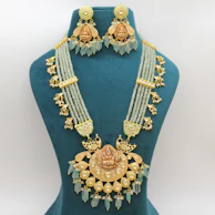 A vintage-inspired 22kt gold necklace with intricate beadwork, showcased on a velvet bust.