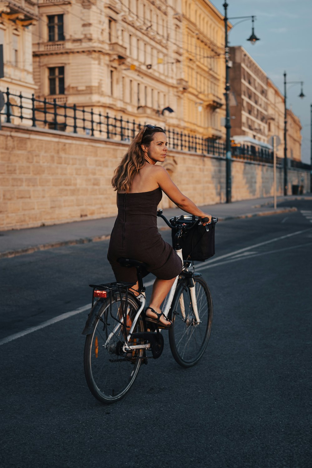 a woman riding a bike down a street