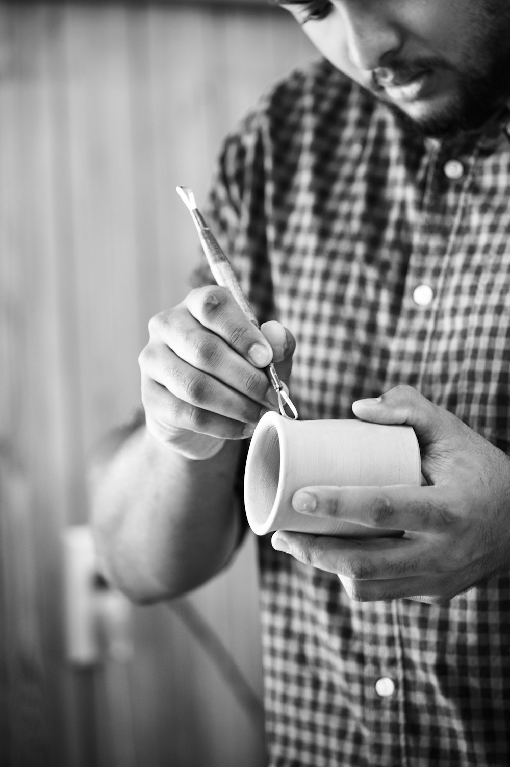 a man holding a cup and a pair of scissors