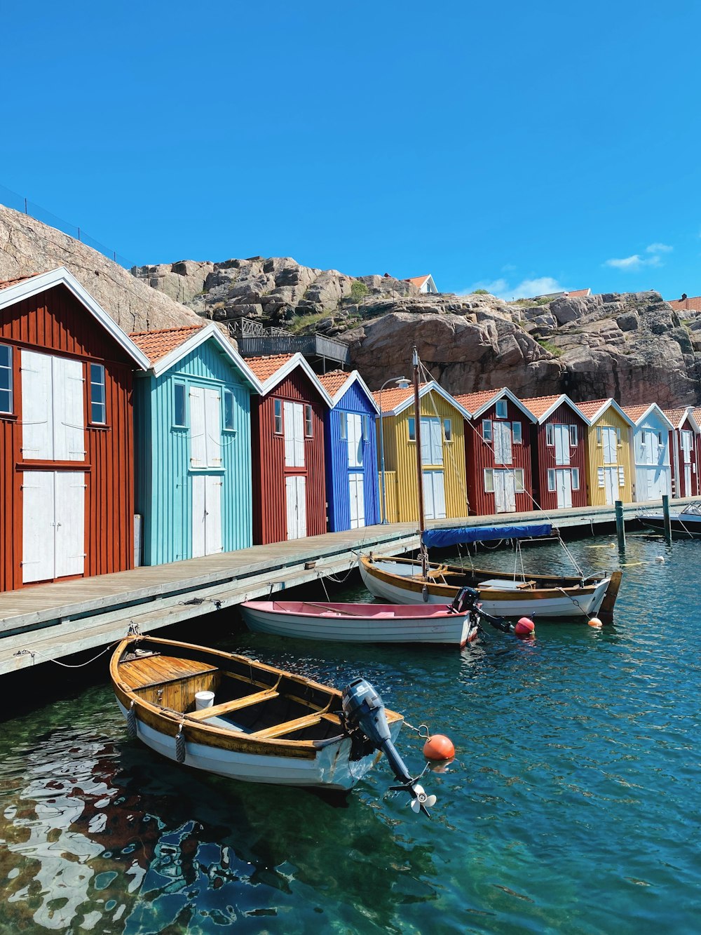 a row of colorful beach huts sitting next to a body of water