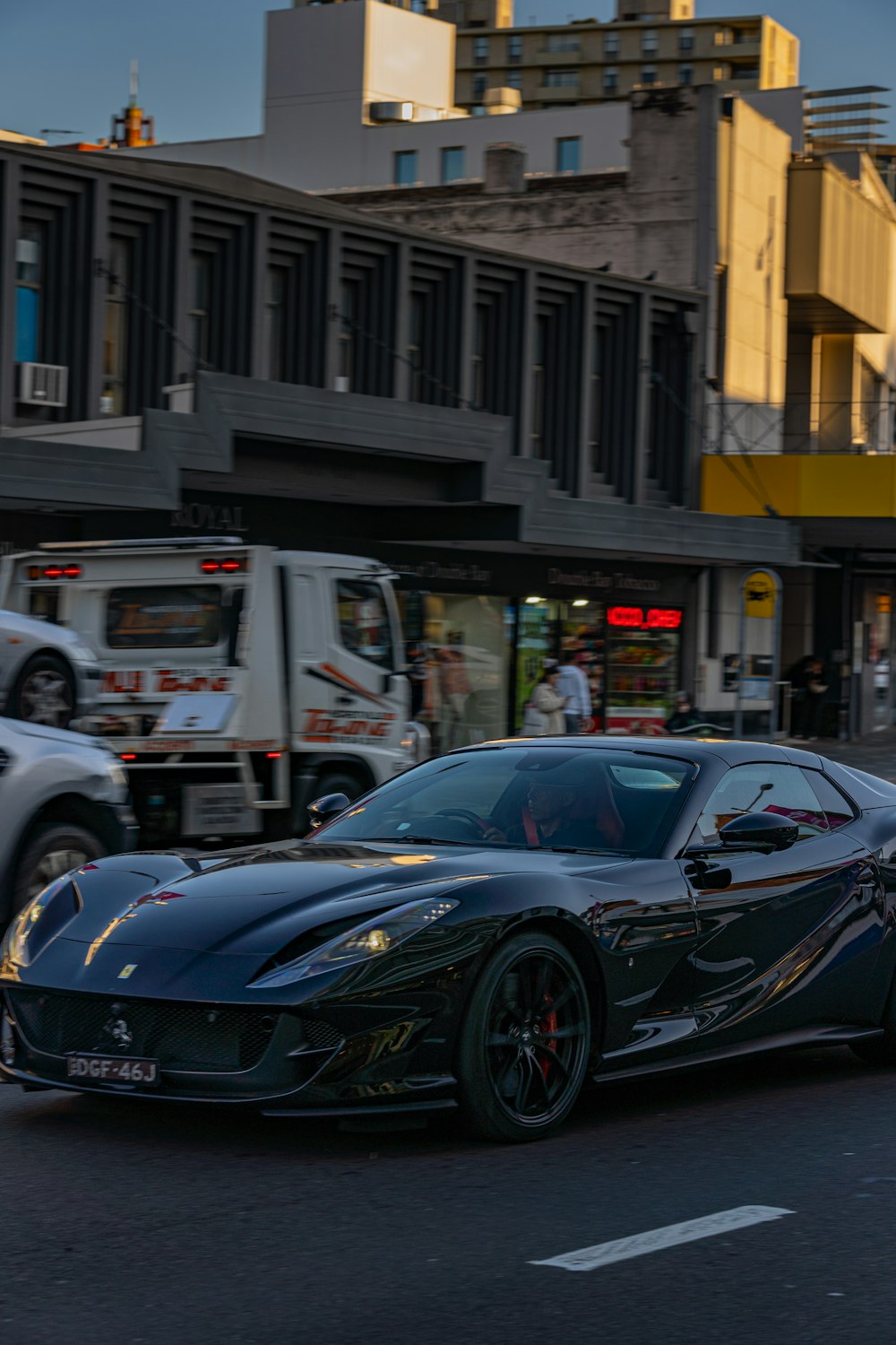 a black sports car driving down a city street