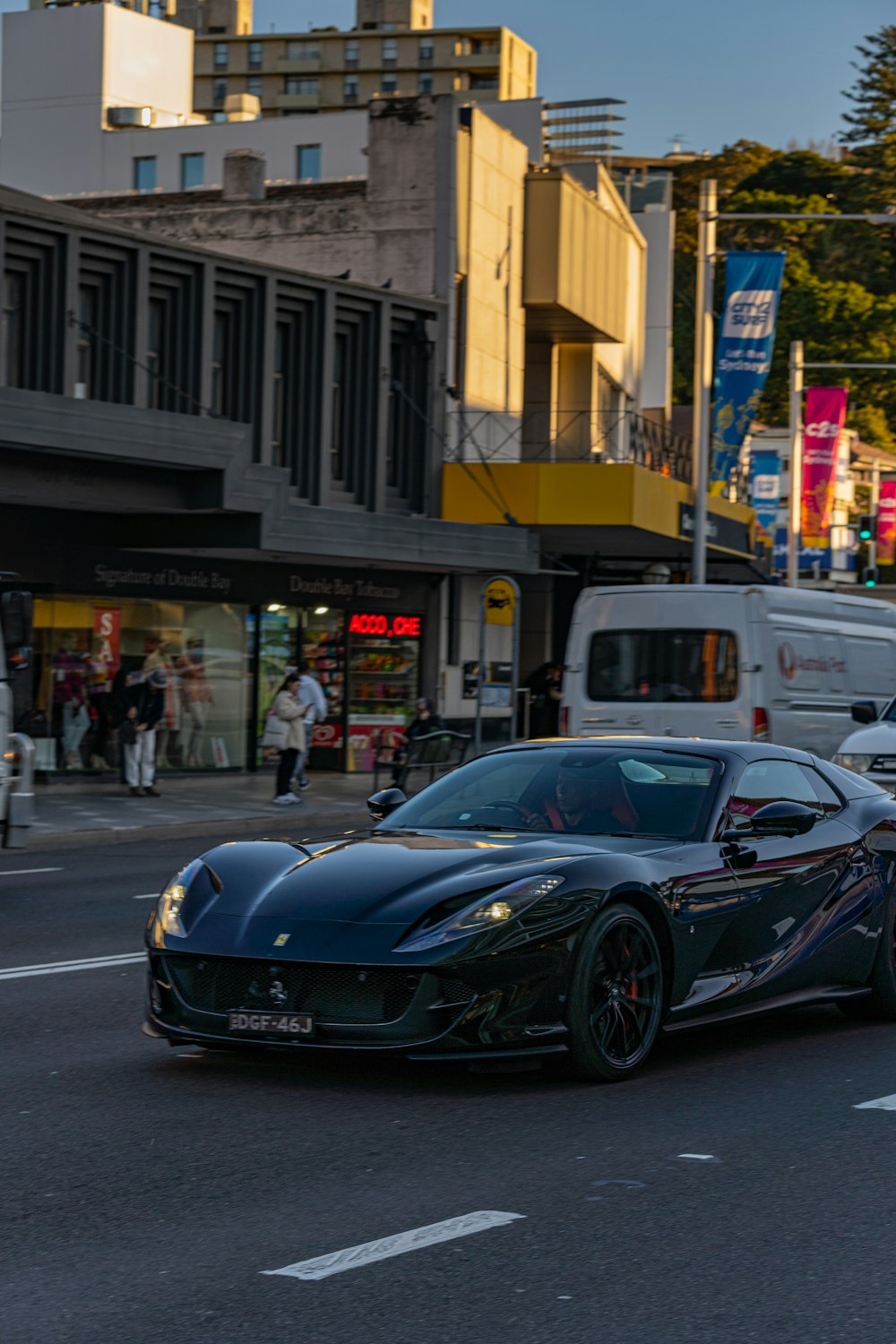 a black sports car driving down a city street